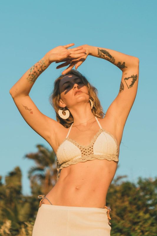 Front view of a natural beige bralette-style artisanal crochet top with silver metallic scallop edging